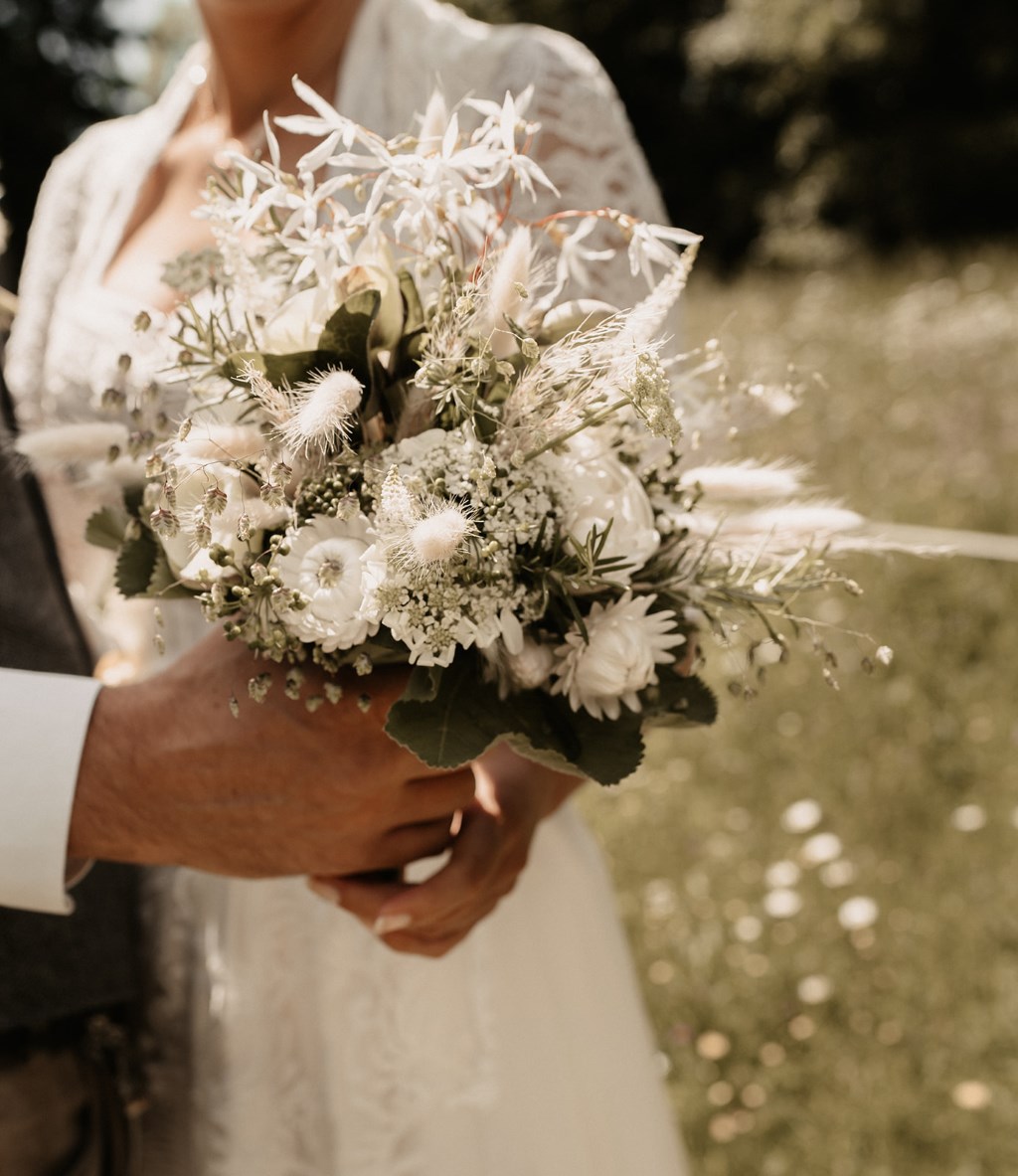 Brautstrauss aus weißen Blüten und Gräsern